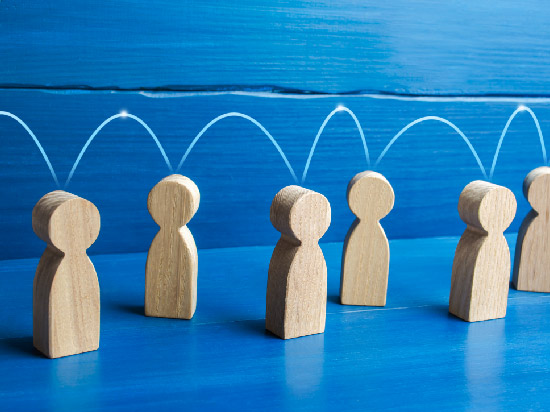 Wooden cutouts depicting people with arched lines connecting the figures.