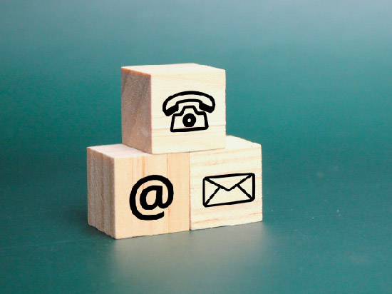 Three small wooden blocks with common communication images imprinted on their face.