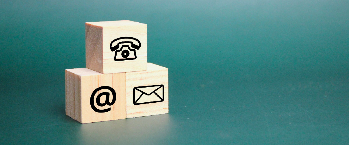 Three small wooden blocks stacked with communication symbos etched onto the face of each block.