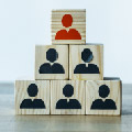 Six wooden blocks stackes as a pyramid with persons busts on the face of the blocks.